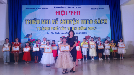 Bà Lâm Thu Hương-Giám đốc Trung tâm Văn hóa, Thể thao và Truyền thanh Thành phố trao giải nhất cho em Huỳnh Võ Yến Vy