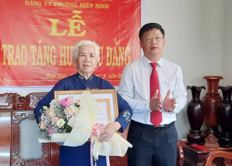Ông Lê Minh Thế- Bí thư Thành uỷ trao Huy hiệu cho đảng viên Nguyễn Thị Phượng