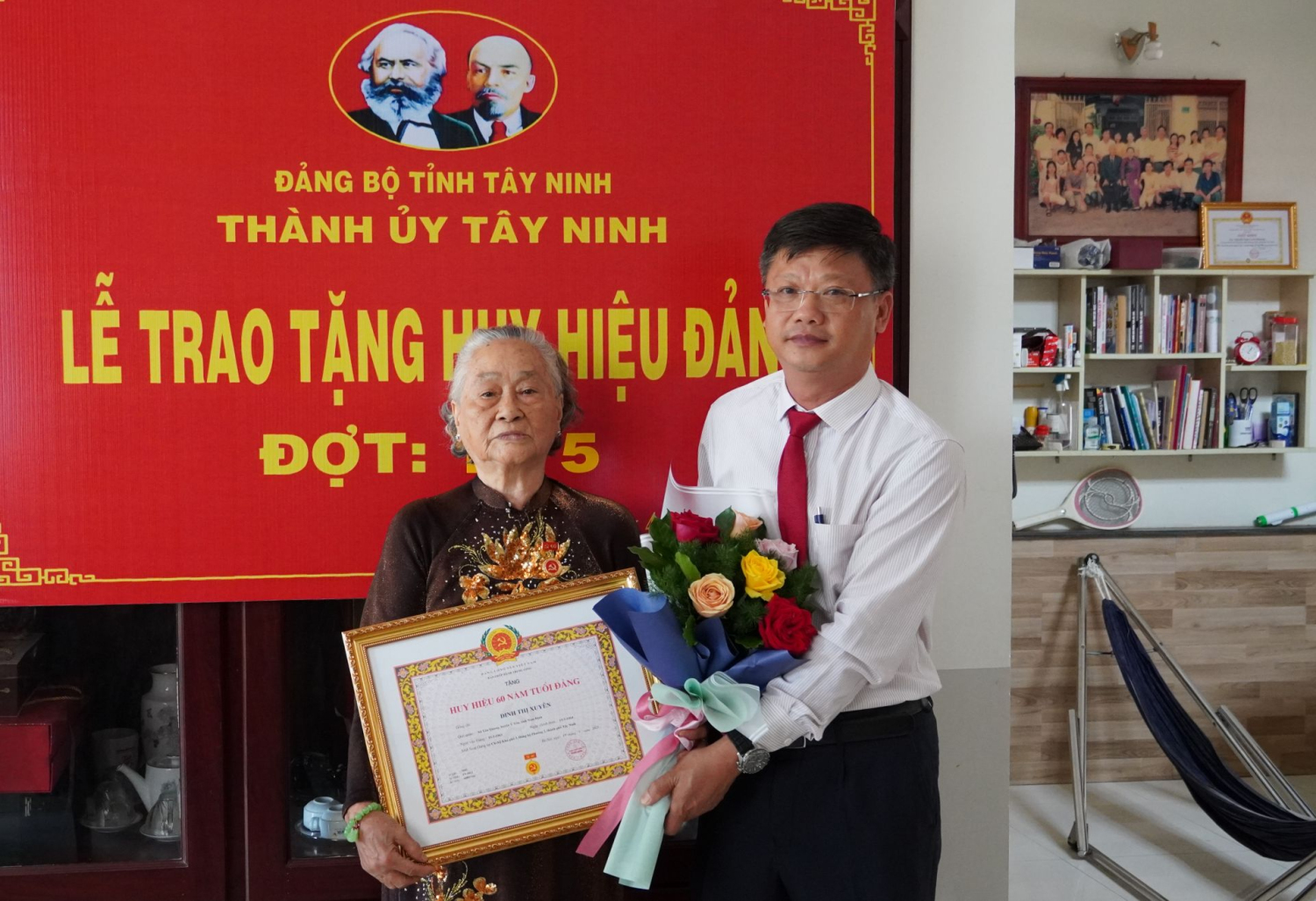 Bí thư Thành uỷ Lê Minh Thế trao Huy hiệu 60 năm tuổi Đảng và tặng hoa chúc mừng đảng viên Đinh Thị Xuyên